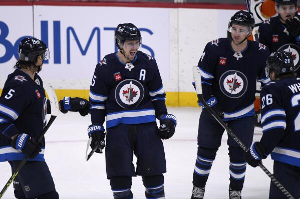 Winnipeg Jets' Mark Scheifele (55) celebrates his goal against the Anaheim Ducks with teammates during the third period of an NHL Hockey game in Winnipeg, Manitoba on Sunday, Dec. 4, 2022. (Fred Greenslade/The Canadian Press via AP)
