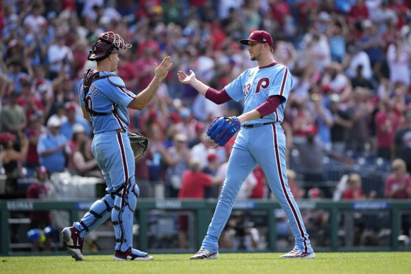 Philadelphia Phillies' Jeff Hoffman, right, and J.T. Realmuto celebrate after the Phillies won a baseball game against the Texas Rangers, Thursday, May 23, 2024, in Philadelphia. (AP Photo/Matt Slocum)