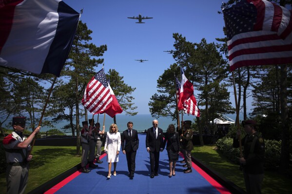 President Joe Biden and First Lady Jill Biden arrive with French President Emmanuel Macron, second left, and his wife Brigitte Macron for a commemorative ceremony to mark D-Day 80th anniversary, Thursday, June 6, 2024 at the US cemetery in Colleville-sur-Mer, Normandy. Normandy is hosting various events to officially commemorate the 80th anniversary of the D-Day landings that took place on June 6, 1944. (AP Photo/Daniel Cole, Pool)