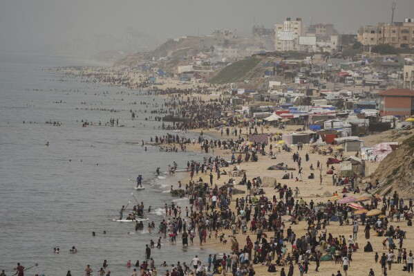 Palestinians spend the day on the beach along the Mediterranean Sea during a heatwave in Deir al Balah, Gaza Strip, Thursday, April 25, 2024. Over 80% of Gaza's population has been displaced by the ongoing war with Israel, and many have relocated to the area. Temperatures hovered near 37 degrees Celsius (100 degrees Fahrenheit). (AP Photo/Abdel Kareem Hana)