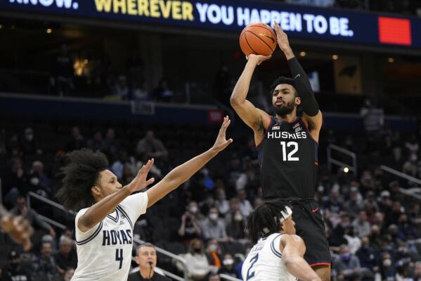 Connecticut forward Tyler Polley (12) shoots against Georgetown forward Jalin Billingsley (4) and guard Dante Harris (2) during the first half of an NCAA college basketball game, Sunday, Feb. 27, 2022, in Washington. (AP Photo/Nick Wass)
