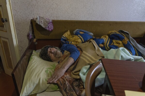 Mykola Soloviov is crippled by illness, as he spends his days bed-ridden in Sloviansk, a city in Donetsk region, his hometown which lies 25 kilometers from the frontline, Ukraine, Saturday, Jan. 27, 2024. Soloviov, 88, is a painter the world does not know. His expressive and imaginative landscapes of eastern Ukraine encapsulate a lost time, and lie undiscovered, tucked away in a modest home under threat of Russian attack. (AP Photo/Vasilisa Stepanenko)