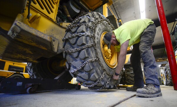 Andy Brown, a highway equipment operator for the Brattleboro, Vt., Public Works Department, puts chains onto a vehicle on Friday, Jan. 5, 2024, in anticipation of this weekend's snow storm. (Kristopher Radder /The Brattleboro Reformer via AP)