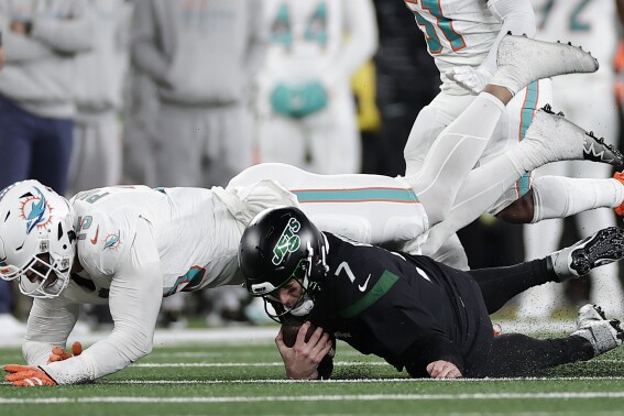 Miami Dolphins linebacker Jaelan Phillips (15) sacks New York Jets quarterback Tim Boyle (7) during the fourth quarter of an NFL football game, Friday, Nov. 24, 2023, in East Rutherford, N.J. (AP Photo/Adam Hunger)