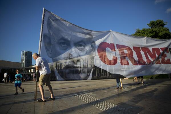 FILE - Israelis carry a banner showing Israeli Prime Minister Benjamin Netanyahu during a protest against the Israel Jewish nation bill, in Tel Aviv, Israel, July 30, 2018. Netanyahu is set to return to power, from where he could try to make his years-long legal troubles disappear through new legislation advanced by his far-right and ultra-Orthodox allies. Critics say such a legal crusade is an assault on Israel’s democracy. (AP Photo/Oded Balilty, File)