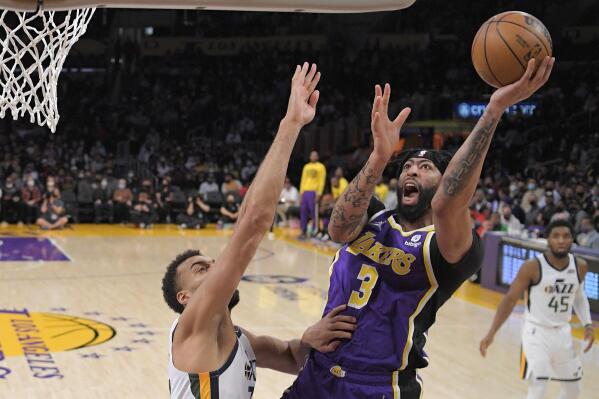 Los Angeles Lakers forward Anthony Davis, center, shoots as Utah Jazz center Rudy Gobert defends during the first half of an NBA basketball game Wednesday, Feb. 16, 2022, in Los Angeles. (AP Photo/Mark J. Terrill)