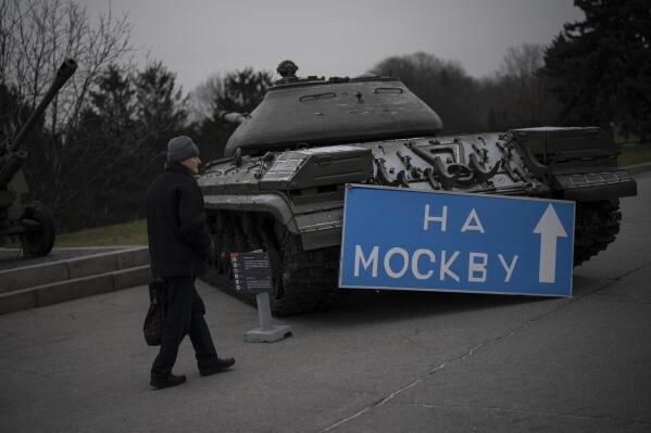 A man walks by a sign that reads "to Moscow" placed on an old tank displayed at a war museum in Kyiv, Ukraine, Wednesday, Jan. 25, 2023. (AP Photo/Daniel Cole)