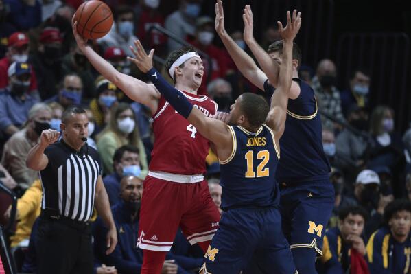 Rutgers guard Paul Mulcahy (4) is pressured by Michigan guard DeVante' Jones (12) and center Hunter Dickinson (1) during the first half of an NCAA college basketball game Tuesday, Jan. 4, 2022, in Piscataway, N.J. (Andrew Mills/NJ Advance Media via AP)