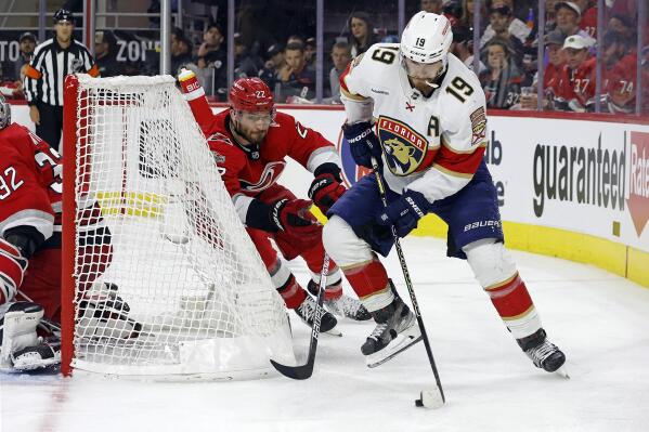 Florida Panthers' Matthew Tkachuk (19) controls the puck behind the net as Carolina Hurricanes' Brett Pesce (22) closes in during the third period of Game 2 of the NHL hockey Stanley Cup Eastern Conference finals in Raleigh, N.C., Saturday, May 20, 2023. (AP Photo/Karl B DeBlaker)