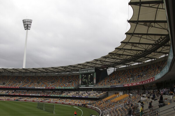 FILE - Spectators make their way home after play had been suspended due to heavy rain during the second day of the first cricket test match between Australia and South Africa at the Gabba stadium in Brisbane, Australia, Saturday, Nov. 10, 2012. The cricket stadium that Brisbane Olympics backers pitched as the centerpiece venue for the 2032 Summer Games is set to be demolished and rebuilt.(AP Photo/Tertius Pickard, File)