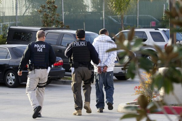 FILE - In this March 30, 2012 file photo, Immigration and Customs Enforcement (ICE) agents take a suspect into custody as part of a nationwide immigration sweep in Chula Vista, Calif. San Diego County Sheriff Bill Gore says he will comply with U.S. Immigration and Customs Enforcement's request for information on four people with criminal records, becoming the first state or local law enforcement official in the country to so honor such requests among a spate of jurisdictions whose laws sharply restrict cooperation with immigration authorities. (AP Photo/Gregory Bull,File)
