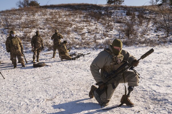 Serhii Pozniak, foreground, a sniper unit commander with the 27th national guard brigade who lost a leg after stepping on a mine, takes part in military training near Kyiv, Ukraine, on Feb. 17, 2025. (AP Photo/Evgeniy Maloletka)