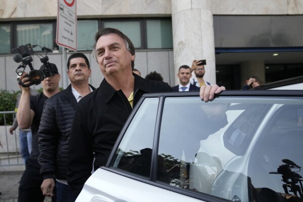 FILE - Brazil's former President Jair Bolsonaro gets into a car after landing at the airport in Rio de Janeiro, Brazil, Thursday, June 29, 2023. Bolsonaro was admitted to a hospital in Sao Paulo on Aug. 23, 2023 for what a close aide described as routine health examinations. (AP Photo/Silvia Izquierdo, File)