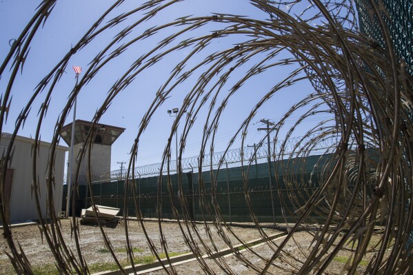 ARCHIVO - En esta foto del 17 de abril de 2019, revisada por el mando militar, se ve la torre de control a través de la alambrada de púas en la prisión Camp VI de la base naval de Guantánamo, Cuba. (AP Foto/Alex Brandon, File)