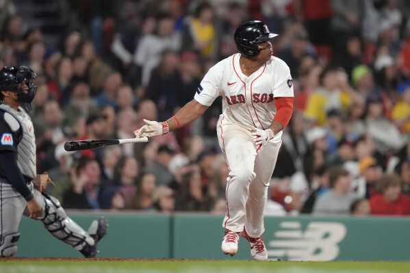 Boston Red Sox's Rafael Devers drops his bat after hitting a two-run double next to Cleveland Guardians' Bo Naylor during the sixth inning of a baseball game Tuesday, April 16, 2024, in Boston. (AP Photo/Steven Senne)
