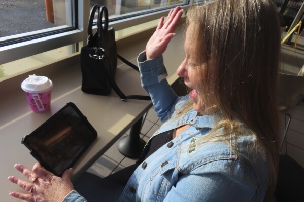 Elaine Vallaster reacts to a winning spin while playing an internet slots game on her tablet in Hazlet, N.J. on Friday, Nov. 24, 2023. Internet gambling is currently offered in six states but has been slow to catch on more widely in the U.S. (AP Photo/Wayne Parry)