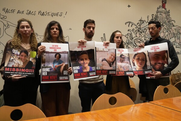 From the left, Adva Gutman, Ayelet Sela bin Nun, Alon Adar, Adva Adar and Daniel Toledano, hold portraits of relatives held hostages by the Hamas militants during a press conference at the Paris town hall, Tuesday, Oct. 31, 2023 in Paris. Families of Israelis taken hostage by Hamas militants on Oct. 7 demand their release and ask for support from the international community. Israel says 240 people were taken by Hamas during the attack. (AP Photo/Michel Euler)