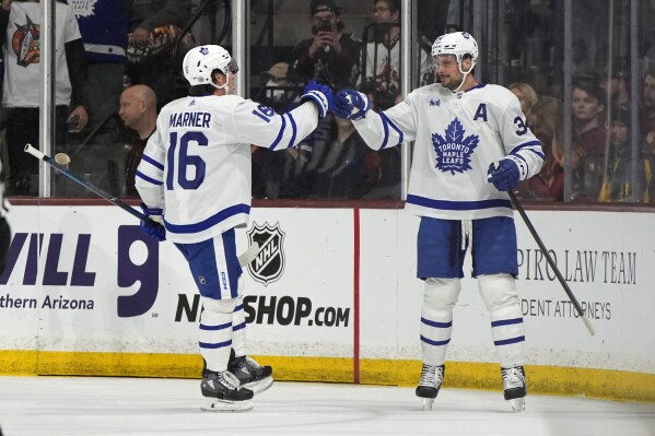 Toronto Maple Leafs center Auston Matthews (34) celebrates with right wing Mitchell Marner after scoring his 50th goal of the season, against the Arizona Coyotes during the first period ofan NHL hockey game Wednesday, Feb. 21, 2024, in Tempe, Ariz. (APPhoto/Rick Scuteri)