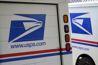 FILE - In this Aug. 18, 2020, file photo, mail delivery vehicles are parked outside a post office in Boys Town, Neb. Oshkosh Defense says, Tuesday, June 22, 2021, it will make new delivery vehicles for the U.S. Postal Service in Spartanburg, S.C., creating 1,000 new jobs. The Wisconsin company says it will reconfigure a warehouse with features needed to do large-scale manufacturing. (AP Photo/Nati Harnik, File)