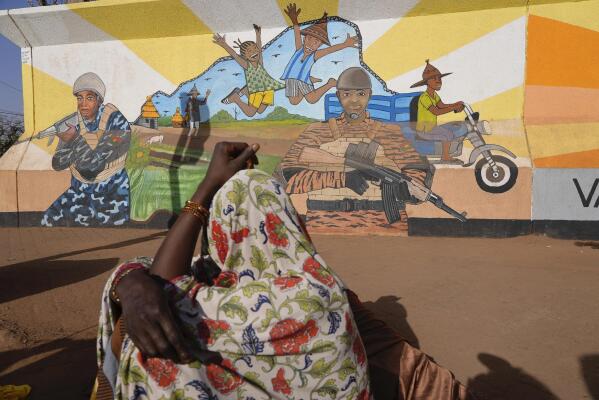 A woman looks at a mural in Ouagadougou, Burkina Faso, Wednesday March 1, 2023. Burkina Faso has been wracked by violence linked to al-Qaida and the Islamic State group that has killed thousands, but some civilians say they are even more afraid of Burkina Faso’s security forces, whom they accuse of extrajudicial killings. The military junta has denied its security forces were involved, but a frame-by-frame analysis by The Associated Press of the 83-second video shows the killings happened inside a military base in the country’s north. (AP Photo)