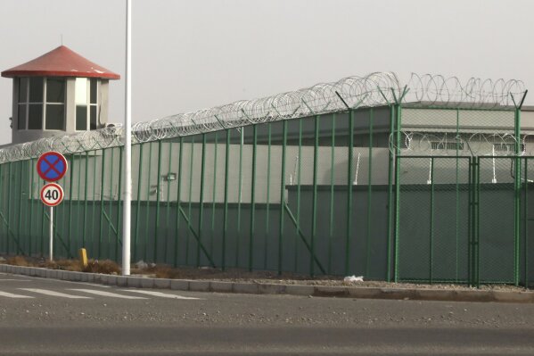 FILE - In this Dec. 3, 2018, file photo, a guard tower and barbed wire fences surround an internment facility in the Kunshan Industrial Park which has previously been revealed by leaked documents to be a forced indoctrination camp in Artux in western China's Xinjiang region. A database obtained by The Associated Press offers the fullest and most personal view yet into how Chinese officials decided who to put into and let out of detention camps, as part of a massive crackdown that has locked away more than a million ethnic minorities, most of them Muslim. (AP Photo/Ng Han Guan, File)