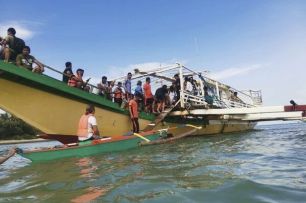 In this handout photo provided by the Philippine Coast Guard, rescued passengers arrive on a boat in Polillo, Quezon province, northeastern Philippines on Thursday Aug. 3, 2023. The Philippine coast guard rescued all 67 people from a ferry boat that struck a floating object and took on water Thursday off a northeastern province, in the second ferry accident to hit the country in a week, officials said. (Philippine Coast Guard via AP)