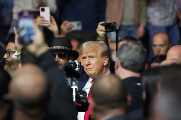 FILE - Former President Donald Trump arrives at the UFC 295 mixed martial arts event Saturday, Nov. 11, 2023, in New York. Trump has spent less time campaigning in early-voting states than many of his Republican primary rivals. But his campaign has been bolstering his schedule with appearances at major sporting events. Video of his appearances routinely rack up hundreds of thousands of views across social media. (AP Photo/Frank Franklin II, File)