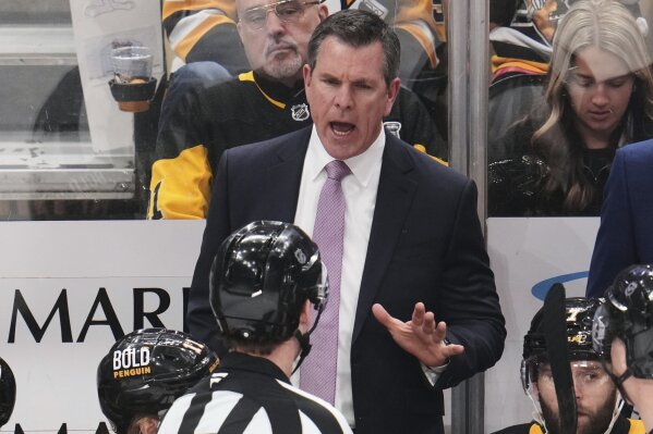 Pittsburgh Penguins head coach Mike Sullivan talks with referee Brandon Schrader during the third period of an NHL hockey game against the Washington Capitals in Pittsburgh, Thursday, April 17, 2025. (AP Photo/Gene J. Puskar)