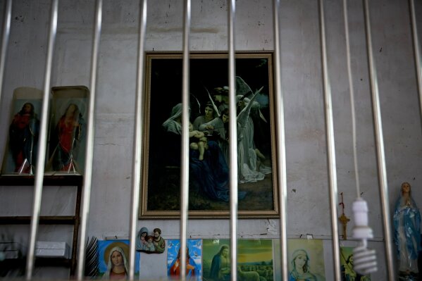
              In this Tuesday, March 27, 2018, photo, Catholic religious paintings and figures are displayed behind bars at an underground Catholic church in Jiexi county in south China's Guangdong province. A group that monitors Christianity in China says the government is ratcheting up a crackdown on congregations in Beijing and several Chinese provinces, destroying crosses, burning Bibles and ordering followers to sign papers renouncing their faith. (AP Photo/Andy Wong)
            