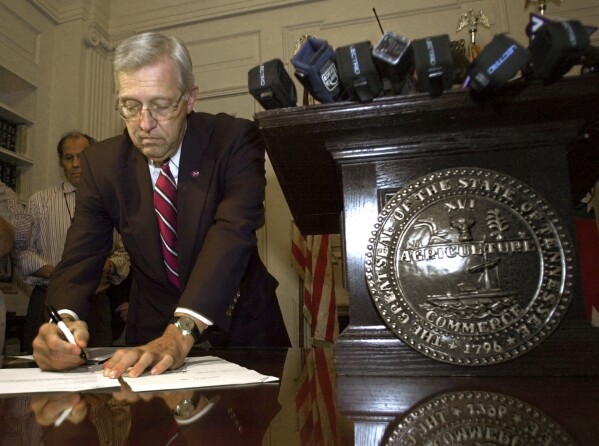 FILE - Tennessee Gov. Don Sundquist signs a bill shortly before midnight in his office in Nashville, Tenn., on June 30, 2002, granting him authority to continue essential services in the state for five more days. Former governor Sundquist died at Baptist East Hospital in Memphis on Sunday, Aug. 27, 2023, according to a family spokeswoman. (AP Photo/Mark Humphrey, File)