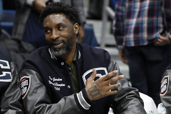 FILE- Former UConn and NBA player Ben Gordon sits on the sideline during a ceremony honoring the 2004 men's championship basketball team during halftime of an NCAA college basketball game, Sunday, Jan. 28, 2024, in Hartford, Conn. Gordon, who was arrested after a Connecticut juice shop disturbance last year, could see the charges erased from his record, under a probation program approved by a judge Monday, March 25, 2024. (AP Photo/Jessica Hill, File)