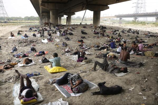 FILE - Homeless people sleep in the shade of a bridge on a hot day in New Delhi, May 20, 2022. A new study published in Climactic Change on Tuesday, July 12, 2022, calculates just how much climate-related loss richer countries have caused poorer countries through their carbon emissions. (AP Photo/Manish Swarup, File)