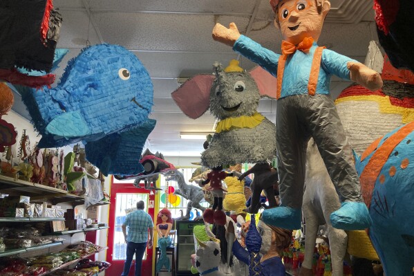Francisco Rodríguez looks out the window of his shop Casa de Piñatas in Albuquerque, N.M., Sept. 7, 2023. Rodríguez said many older piñata artists have retired but he's hopeful the next generation will take an interest in the craft. On Friday, Sept. 8, the U.S. Postal Service released its latest collection of special stamps, this time highlighting the piñata as part of a monthlong recognition of Hispanic heritage in the U.S. (AP Photo/Susan Montoya Bryan)