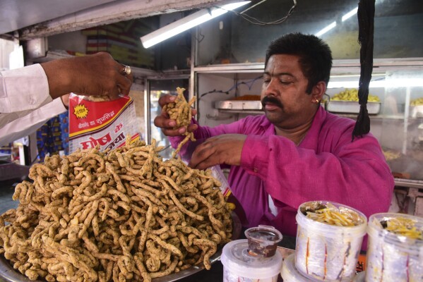 A shopkeeper sells local snack prepared with Bhang or cannabis, during Holi festivities in Bikaner, in the Indian state of Rajasthan, India, Thursday, March 21, 2024. Holi, the Hindu festival of colors that also heralds the coming of spring, is being celebrated across the country Monday. Bhang is a popular drink during Holi. (AP Photo/Dinesh Gupta)