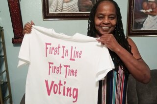 In this photo taken by her son, Betty Riddle in Sarasota, Fla., Sunday, April 26, 2020, holds the T-shirt she wore on March 17, 2020, when she voted for the first time. She was barred from voting in Florida until a federal judge temporarily blocked the state from preventing her and 16 other felons from voting because of unpaid legal financial obligations. (Courtesy of Rickie Riddle via AP)