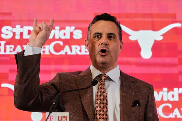 Texas' new coach Sean Miller gives a "Hook'em Horns" sign after he was introduced during an NCAA college basketball news conference in Austin, Texas, Tuesday, March 25, 2025. (AP Photo/Eric Gay, File)