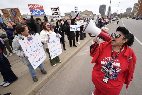 Internal Revenue Service employee Diane LeDesna, from Kansas City, Mo., leads protesters supporting federal workers outside the IRS regional office Saturday, March 15, 2025, in Kansas City, Mo. (AP Photo/Charlie Riedel)