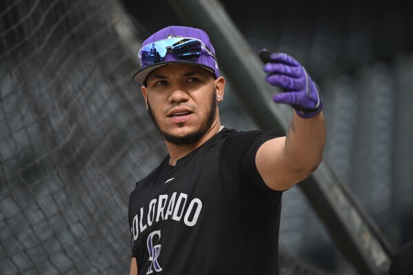 Colorado Rockies' Thairo Estrada swings his arm prior to a baseball game against the Philadelphia Phillies, Wednesday, May 21, 2025, in Denver. (AP Photo/Geneva Heffernan)
