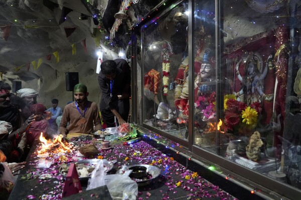 Hindu devotees perform their rituals during an annual festival in an ancient cave temple of Hinglaj Mata in Hinglaj in Lasbela district in Pakistan's southwestern Baluchistan province, Friday, April 26, 2024. More than 100,000 Hindus are expected to climb mud volcanoes and steep rocks in southwestern Pakistan as part of a three-day pilgrimage to one of the faith's holiest sites. (AP Photo/Junaid Ahmed)