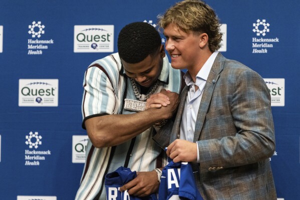 New York Giants first round draft picks Abdul Carter, left, and Jaxson Dart shake hands during an NFL football press conference at the team's training facility in East Rutherford, N.J., Friday, April 25, 2025. (AP Photo/Stefan Jeremiah)