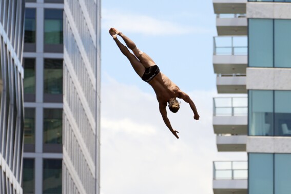 A men's competitor David Colturi takes a practice dive in the Red Bull Cliff Diving World Series, Saturday, June 8, 2024, in Boston. (AP Photo/Michael Dwyer)