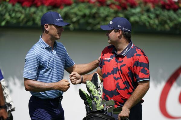 Billy Horschel, left, and Patrick Reed, right, greet each other on the first tee during the first round of the Tour Championship golf tournament Thursday, Sept. 2, 2021, at East Lake Golf Club in Atlanta. (AP Photo/Brynn Anderson)