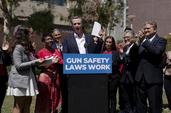 California Gov. Gavin Newsom, center, celebrates after singing a gun control law as he is surrounded by state officials including state Sen. Bob Hertzberg, right, state Sen. Anthony Portantino, second right, Attorney General Rob Bonta, third left, and gun violence survivors, Mia Tretta, and Arvis Jones, at Santa Monica College campus in Santa Monica, Calif., Friday, July 22, 2022. Newsom signed a gun control law Friday, a month after conservative justices overturned women's constitutional right to abortions and undermined gun control laws in states including California (AP Photo/Jae C. Hong)