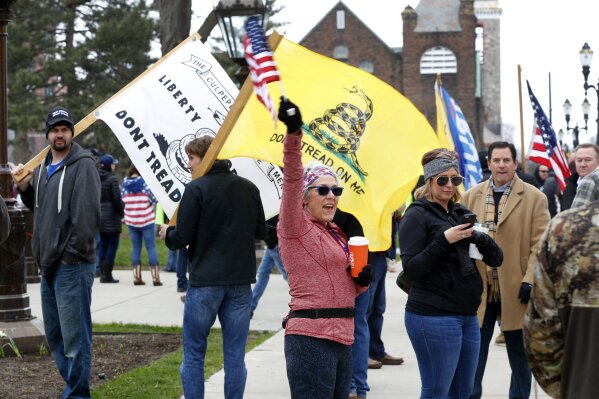 Protesters attend a rally outside the State Capitol in Lansing, Mich., Wednesday, April 15, 2020. Flag-waving, honking protesters drove past the Michigan Capitol on Wednesday to show their displeasure with Gov. Gretchen Whitmer's orders to keep people at home and businesses locked during the new coronavirus COVID-19 outbreak. (AP Photo/Paul Sancya)