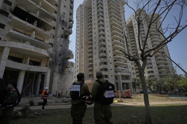 Israeli security forces inspect a residential building hit by a missile launched from Iran in Petah Tikva, Israel, Monday, June 16, 2025. (AP Photo/Baz Ratner)