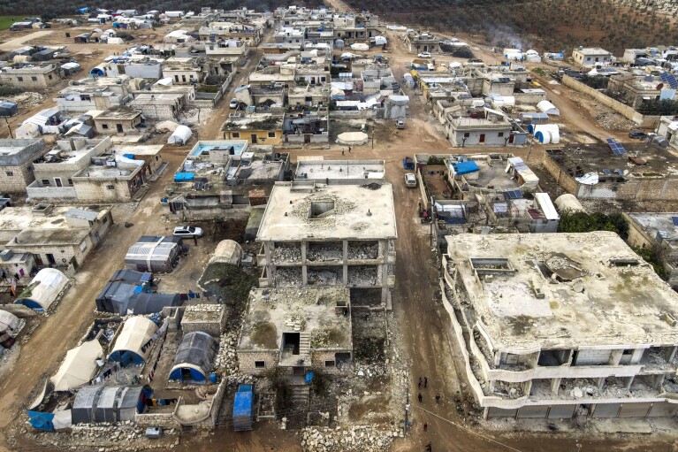 An aerial view shows tents used as shelters placed next to buildings that were destroyed in the February 2023 earthquake, in Idlib province, Syria, Thursday, Jan. 25, 2024. A year after the devastating 7.8 magnitude earthquake struck southern Turkey and northwestern Syria, a massive rebuilding effort is still trudging along. The quake caused widespread destruction and the loss of over 59,000 lives. (AP Photo/Omar Albam)
