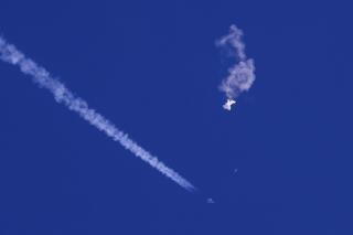 FILE - A fighter jet flies past the remnants of a large balloon after it was shot down above the Atlantic Ocean, just off the coast of South Carolina near Myrtle Beach, Feb. 4, 2023. The missile fired by a U.S. F-22 ended the days-long flight of what the Biden administration says was a surveillance operation that took the Chinese balloon near U.S. military sites. It was an unprecedented incursion across U.S. territory for recent decades, and raised concerns among Americans about a possible escalation in spying and other challenges from rival China. (Chad Fish via AP, File)