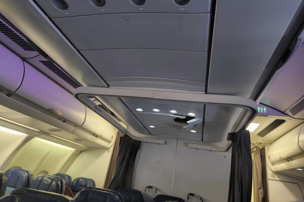 This photo provided by Tara Goodall shows a crack in the ceiling of a Hawaiian Airlines plane that encountered severe turbulence during a flight from Honolulu to Sydney, June 30, 2023. The airline says airport medics assessed and released three injured passengers when the flight landed in Sydney. One passenger and three flight attendants were "referred for further evaluation," the airline said. (Tara Goodall via AP)