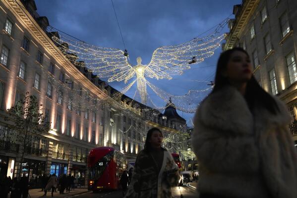 FILE - People walk on Regent Street, in London, on Nov. 17, 2022. Britain’s economy shrank in the three months through October, confirming the toll that rampant inflation and rising interest rates are having on business and industry. (AP Photo/Kin Cheung, File)