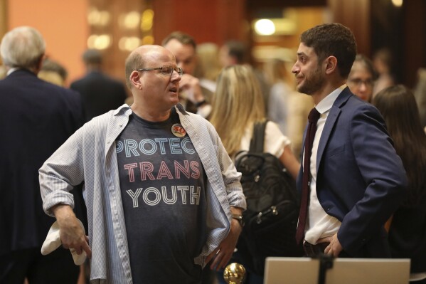Brent Cox, left, talks to Josh Malkin, right, of the South Carolina chapter of the American Civil Liberties Union, right, as they wait to talk to lawmakers in the lobby of the Statehouse on Wednesday, May 1, 2024, in Columbia, S.C. (AP Photo/Jeffrey Collins)